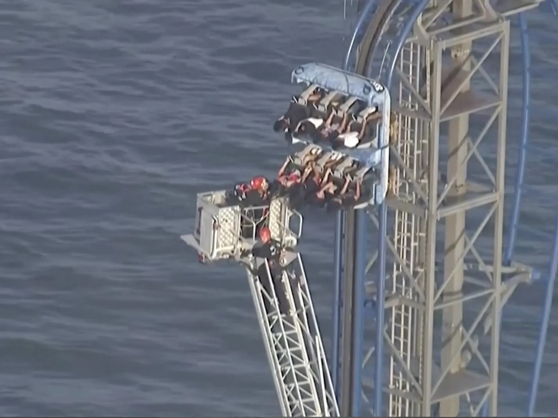 Firefighters work to free riders stuck atop a rollercoaster in Texas