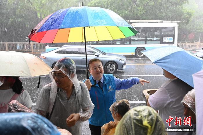 端午遇雨，北京公交青年志愿者为乘客撑伞避雨